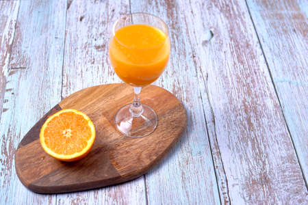 Glass of orange juice wooden table, half orange, wooden floor,の写真素材