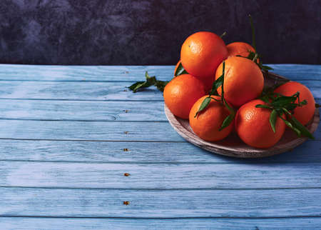 A plate with several oranges on marble background and wooden floor, Empty spaceの写真素材