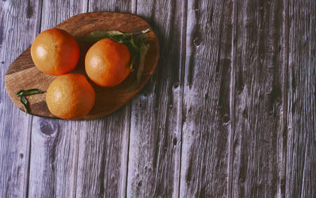 Various oranges on wooden table on dark wooden floorの写真素材