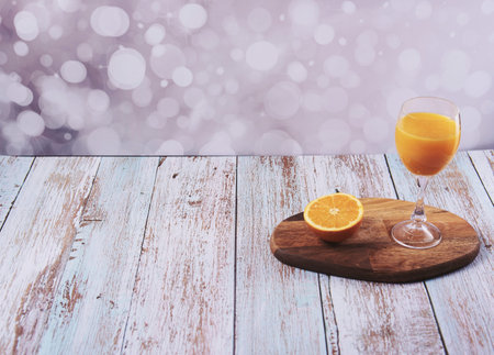 Glass of orange juice wooden table, half orange, wooden floor, bright sound