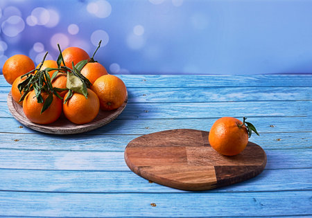 Orange on wooden board and group of oranges on wooden plate on bright background and wooden floorの写真素材