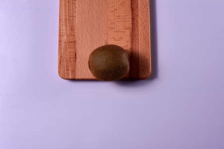 Kiwi on wooden board. Blue background, unique, free space, zenithal viewの写真素材