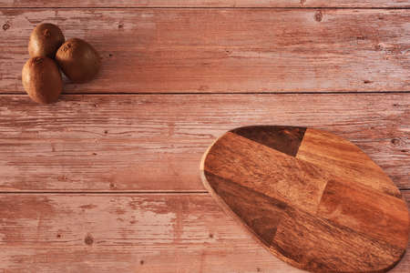 Several kiwis on wooden board. Wooden boards, zenithal view, free space, white bowlの写真素材
