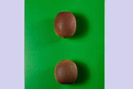 Two kiwis on green background, wood, white background and stone, zenithal viewの写真素材