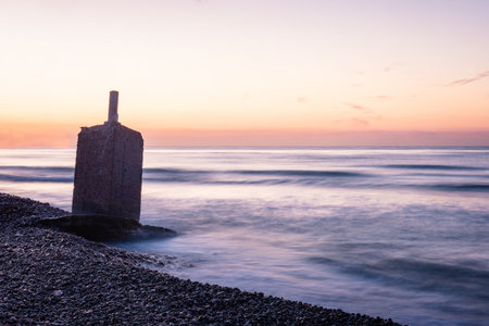 Sunrise Serenity: Tranquil Beachscape with Stone Monolithの写真素材