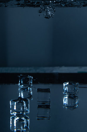 5.Falling Ice Cube into Water with Reflections Belowの写真素材