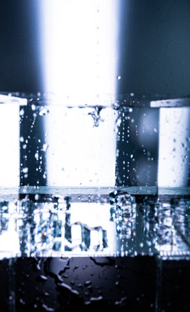 443.Close-up of water surface showing concentric ripple rings and overlapping waves. Blue lighting creates reflections and texture. Image captures fluid motion, wave behavior, and surface tension.の写真素材