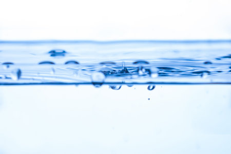 199.Water surface with ripples and bubbles in motion. Blue to white gradient background highlights fluid dynamics, surface tension, and bubble texture.