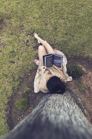 girl sitting in the garden reading a bookの写真素材