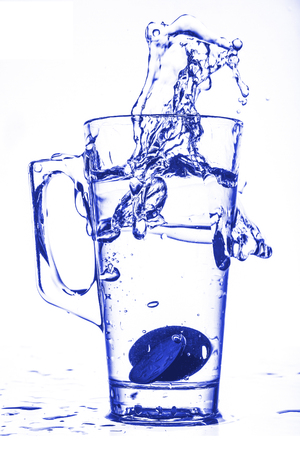 Water Glass with Splashes of Liquid Isolated on a White Backgroundの写真素材