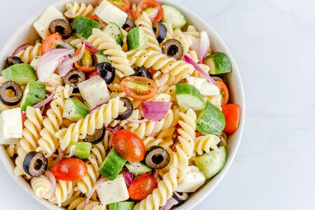 Mediterranean Fusilli Pasta Salad with Tomatoes, Black Olives, Cucumber, Mozzarella Top View Horizontal Photoの写真素材