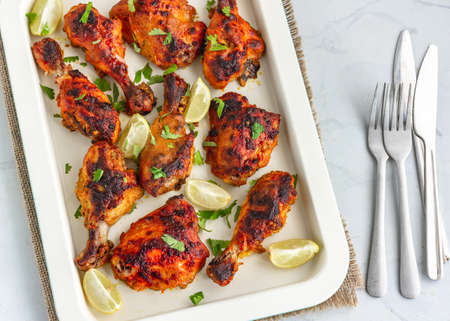 Spicy Grilled Chicken on a Baking Sheet with Lemon, Green Chili Peppers and Cilantro, Top Down Photoの写真素材