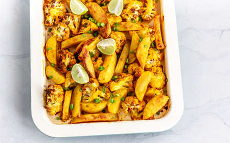 Roasted Cauliflower and Potatoes on a Baking Tray, Indian Style Aloo Gobi, Top View Foodの写真素材