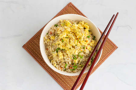 Asian Fried Rice with Fried Eggs in a Bowl Directly Above Photoの写真素材