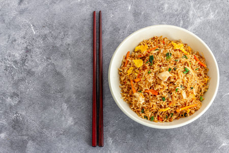 Asian Chicken Fried Rice in a Bowl with Chopsticks Top Down Photoの写真素材