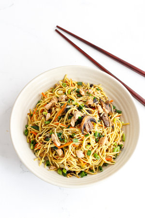 Chinese Stir-Fried Noodles with Vegetables and Meat Top Down Photo on White Backgroundの写真素材