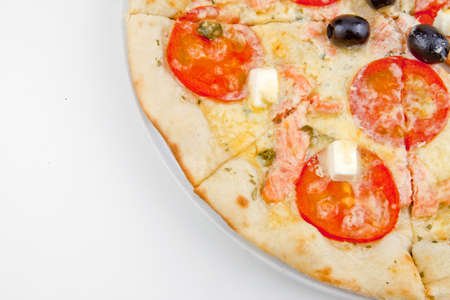 Italian pizza with melted mozzarella cheese, olives and tomato garnished isolated on white backgroundの写真素材
