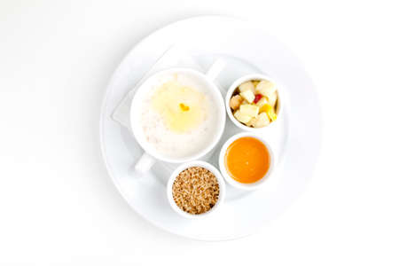 oatmeal in milk with sweet additives on a white plateの写真素材
