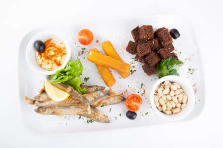 plate with beer snacks, fried croutons, squid, onions and saucesの写真素材