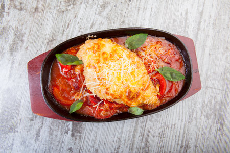 chicken breast with cheese with stewed tomatoes in a panの写真素材