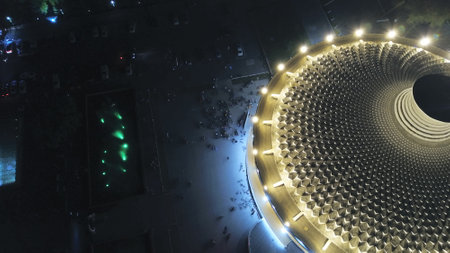 Unusual round roof with lighting. It resembles a portal to another dimension, a black hole, a hot plate. Symmetrical consecration. Golden color with a dark center. The view from the top. Almaty Circusの写真素材