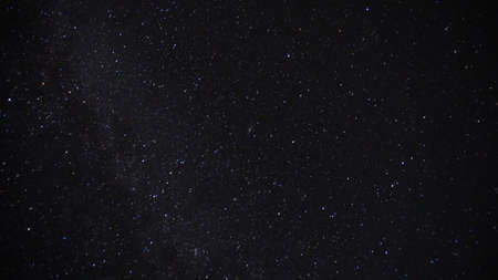 The bright starlight of the night sky. The milky way, meteorites and nebula are visible. The stars illuminate the ground, the grass and the post. Night landscape of the starry sky.の写真素材
