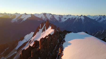 Epic red dawn on top of snowy mountains.の写真素材