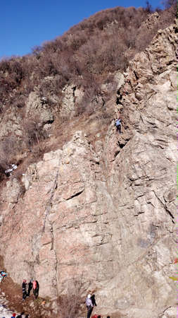 A group of people are engaged in rock climbing.の写真素材
