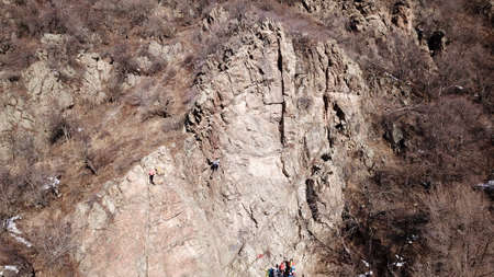A group of people are engaged in rock climbing.の写真素材
