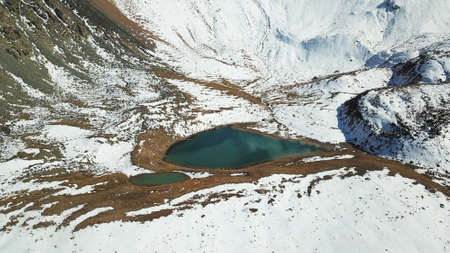Snow-capped mountains and a lake. View from top.の写真素材