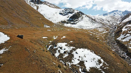 Autumn mountains covered with snow in places.の写真素材
