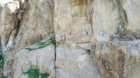 A man climbs up the cliff. Active leisure and sports.の写真素材