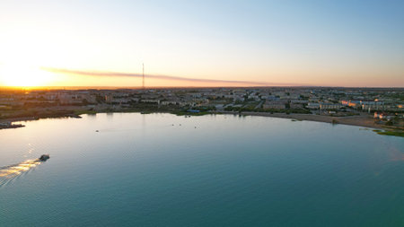The boat sails in the bay at sunset near the cityの写真素材