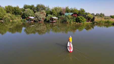 The guy on the sup board is floating on the lake.