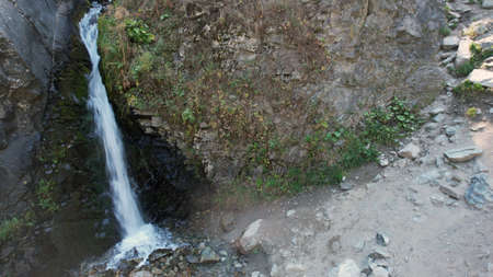 A mountain waterfall in a rocky gorge with forestの写真素材