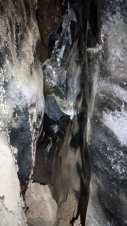 There are rocks and ice inside the ice cave.の写真素材