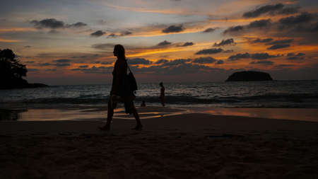 Orange sunset with a view of the sea and people.の写真素材