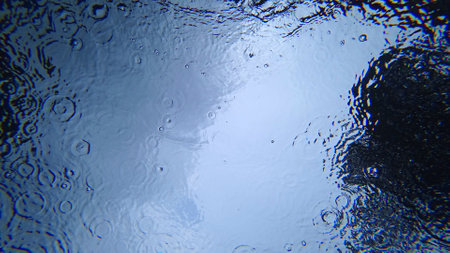 View from under the water to the sky and rainの写真素材