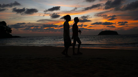 Orange sunset with a view of the sea and people.