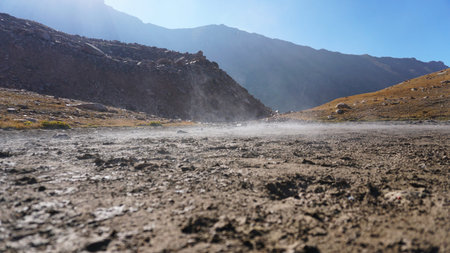 Steam rises from the ground in the mountains.