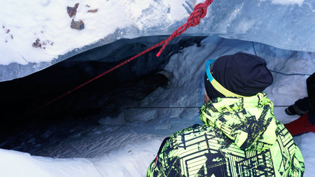 A climber descends into an ice cave in a glacier.の写真素材