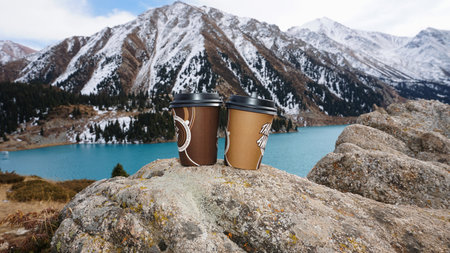 Paper cups on the background of a mountain lakeの写真素材