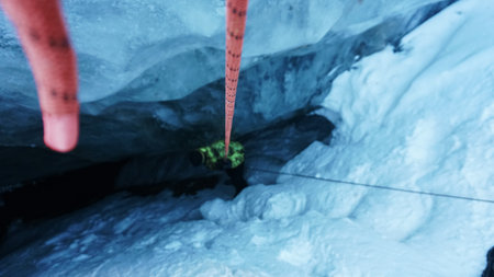 A climber descends into an ice cave in a glacier.の写真素材