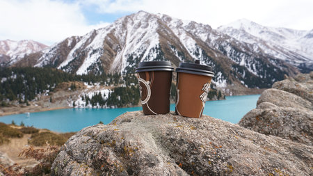 Paper cups on the background of a mountain lakeの写真素材