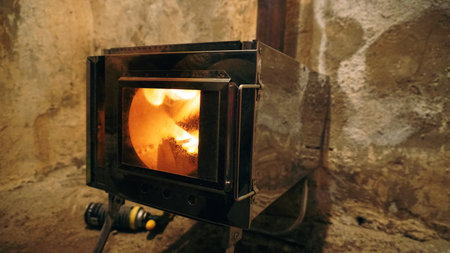 A fire in a camping stove with a glass door.の写真素材
