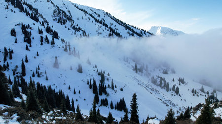 White cumulus clouds in snowy mountains in winterの写真素材