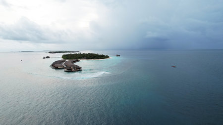 Luxury resort on tropical island in maldives with incoming storm cloudsの写真素材