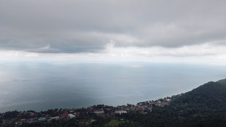 Storm clouds gathering over tropical coastal village and oceanの写真素材