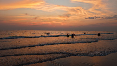 Tourists enjoying sunset at the beachの写真素材