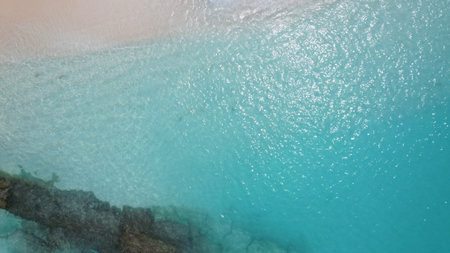 Crystal clear turquoise water gently washing a white sand beachの写真素材